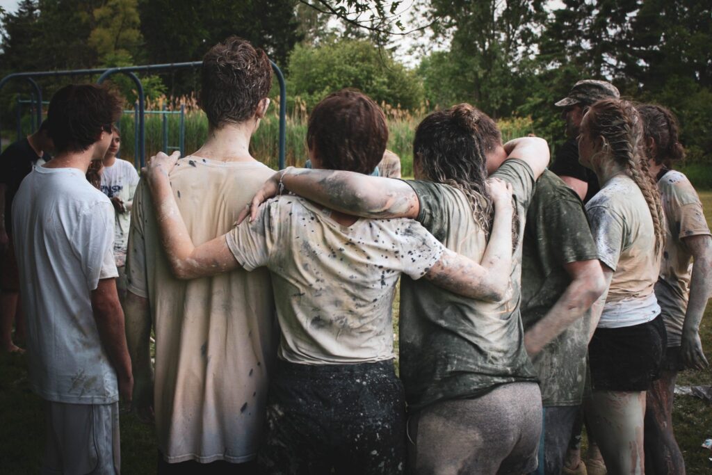 Group of kids holding on to each other covered in paint