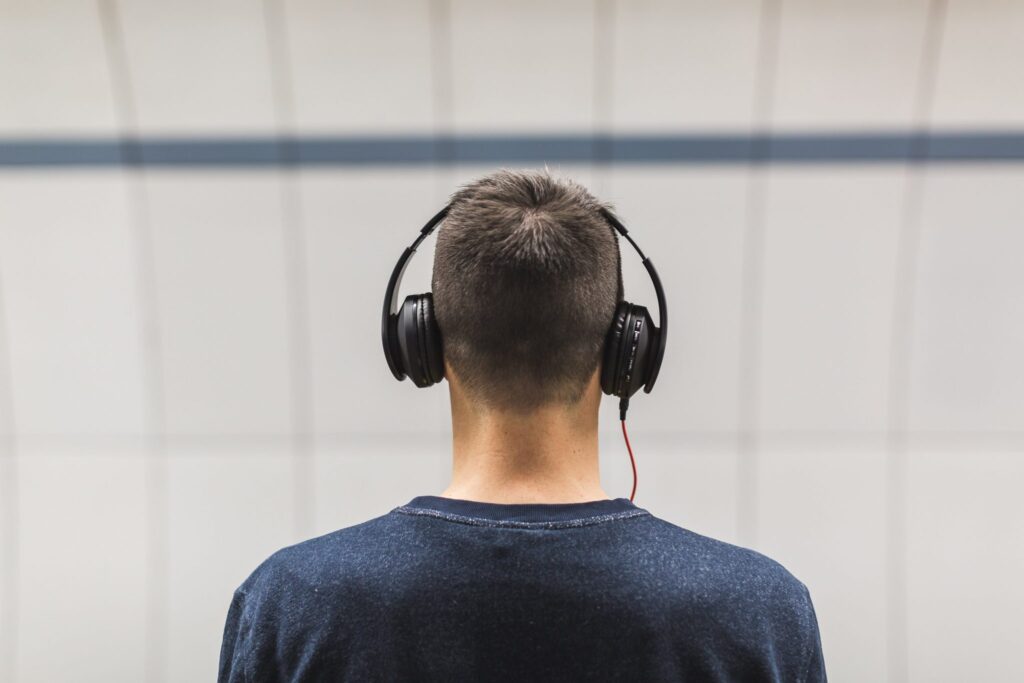 Man with back turned wearing headphones