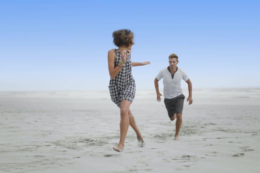 Couple chasing each other on beach