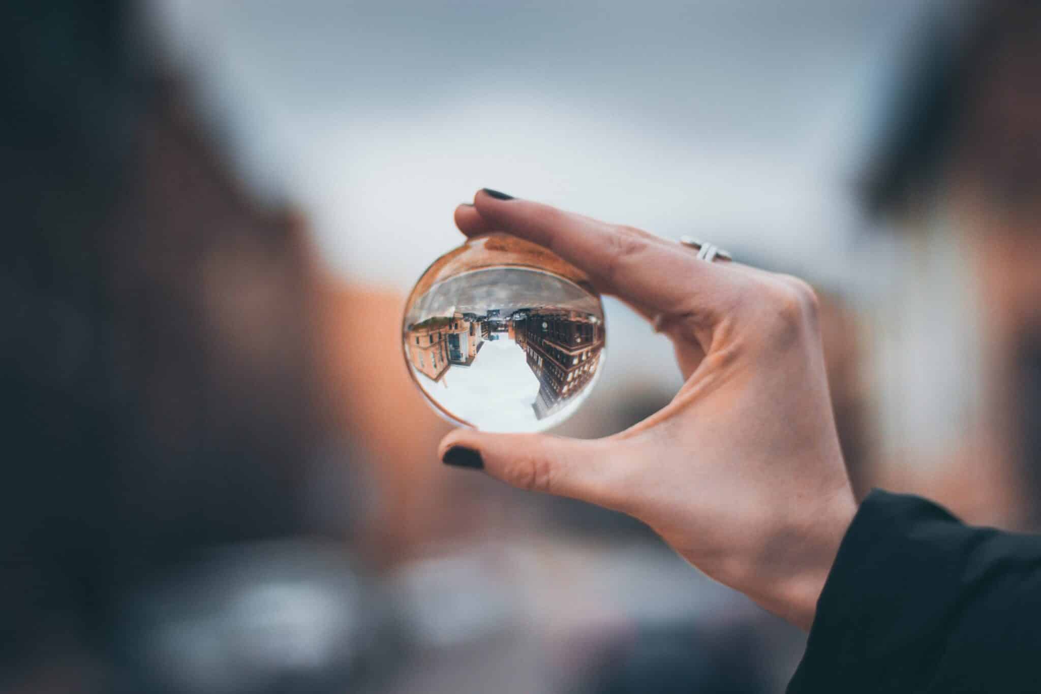 Woman holding a crystal ball with reflection of city inside