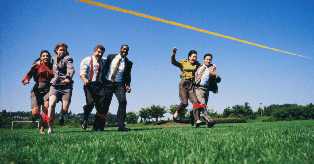 Business people participating in a three legged race